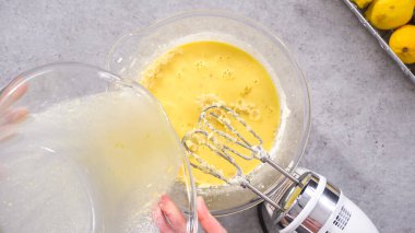 Düz yatıyordu. Adım adım. Limonlu kek hazırlamak için karıştırma kabının içindeki malzemeleri karıştırıyorum..