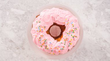 Düz yatıyordu. Adım adım. Funfettti demetli kekin üzerine pembe vanilyalı krema serpiştirilmiş gökkuşağı şekerlemeleri serpiştiriyorum..