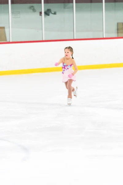 Kleines Mädchen Übt Eiskunstlauf Auf Einer Überdachten Eisbahn — Stockfoto