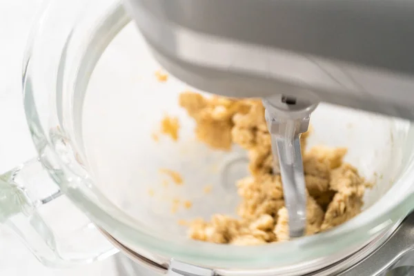Mixing ingredients in standing kitchen mixer to prepare unicorn chocolate chip cookies.