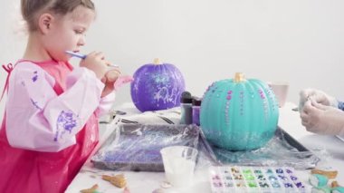 Süslü deniz kızı Cadılar Bayramı balkabağı yaratmak için akrilik boyalı balkabağı boyamak.