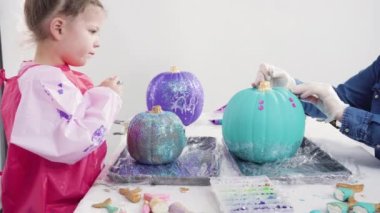 Süslü deniz kızı Cadılar Bayramı balkabağı yaratmak için akrilik boyalı balkabağı boyamak.