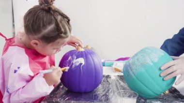 Süslü deniz kızı Cadılar Bayramı balkabağı yaratmak için akrilik boyalı balkabağı boyamak.