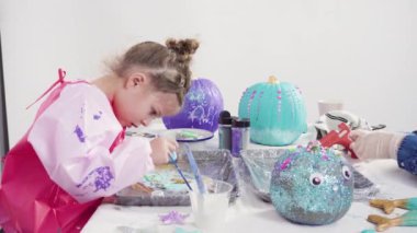 Süslü deniz kızı Cadılar Bayramı balkabağı yaratmak için akrilik boyalı balkabağı boyamak.