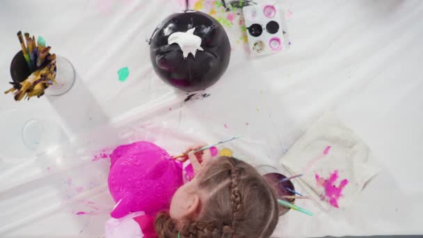Klein Meisje Schilderen Halloween Pompoen Met Acryl Verf — Stockvideo