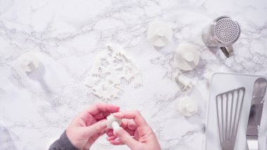 Düz yatıyordu. Adım adım. Mermer tezgahın üzerindeki beyaz fondanla kar tanelerini keserek..