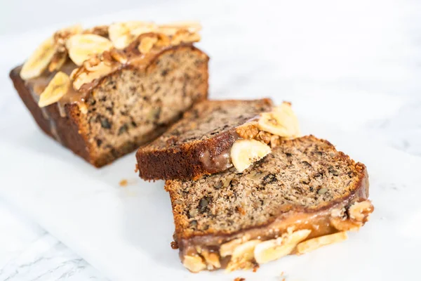 Geschnittenes Bananennussbrot Mit Hausgemachtem Karamell Auf Einem Marmorschneidebrett — Stockfoto