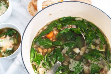 Dökme demir Hollanda fırınında vejetaryen beyaz fasulye çorbası pişirmek.