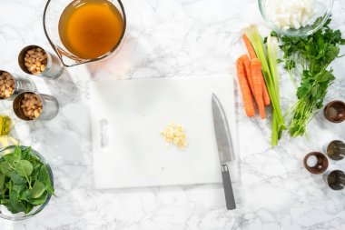 Düz yatıyordu. Beyaz bir kesme tahtasıyla organik sarımsak kesmek.