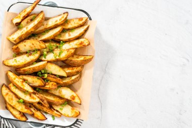 Düz yatıyordu. Beyaz servis tepsisinde baharatlı taze fırınlanmış patates dilimleri..