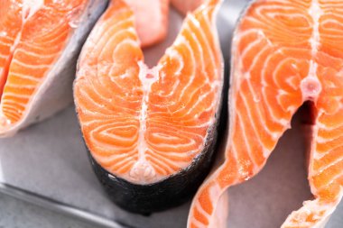 Parşömen kağıdıyla pişirme tepsisinde çiftlik somonu bifteği..