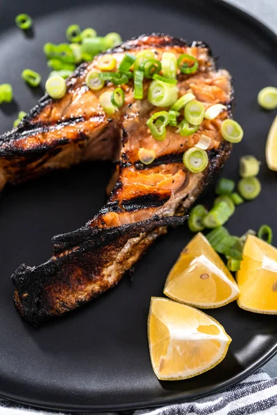 Filetes Salmón Parrilla Adornados Con Cebollas Verdes Plato Negro — Foto de Stock