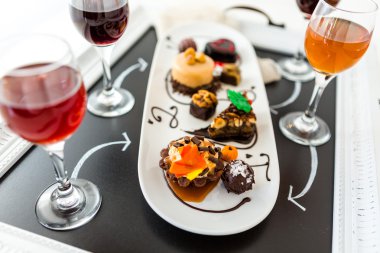 Tasting of wine and pattie chocolate pastries clipart