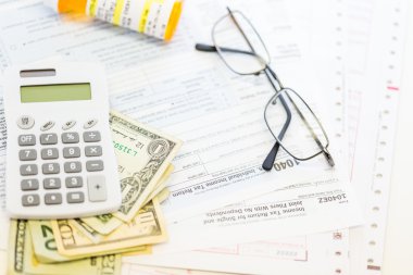 Calculator, cash and glasses - tax return clipart