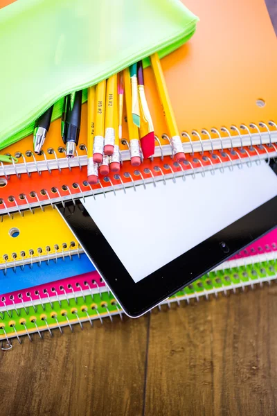 Tabletový počítač, tužky a poznámkové bloky, školní potřeby — Stock fotografie