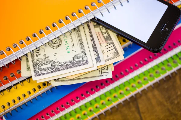 Telefoon, dollars en -laptops, school supplies — Stockfoto