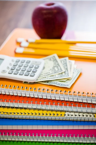 Notebooks, potloden, rekenmachine, contant geld en apple schoolbenodigdheden — Stockfoto