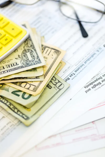 Calculating income tax return and folded cash — Stock Photo, Image