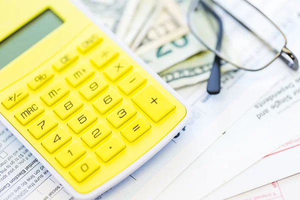 Calculating income tax return and folded cash — Stock Photo, Image