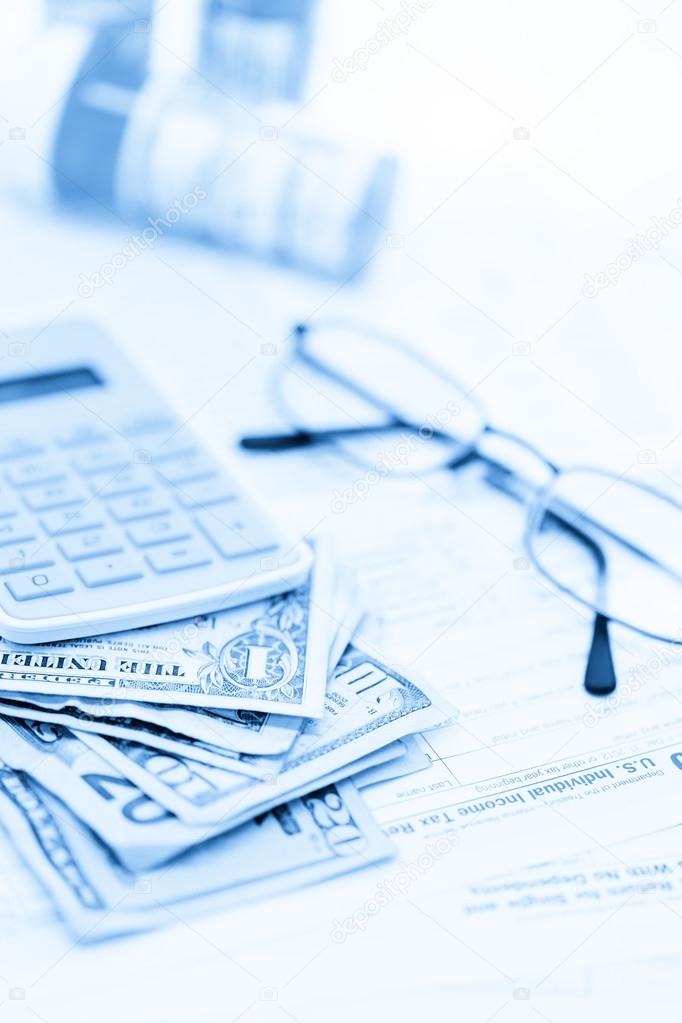 Calculator, cash and glasses - tax return