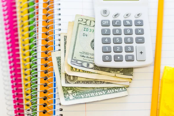 Rekenmachine en contant geld op notebook, school supplies — Stockfoto
