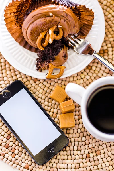 Caramel cupcake and phone — Stock Photo, Image