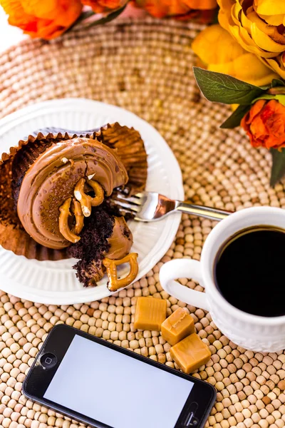 Caramel cupcake and phone — Stock Photo, Image