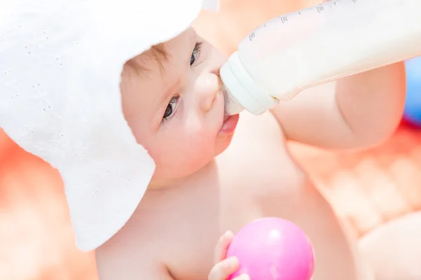 Cute baby girl with bottle of milk — Stock Photo, Image