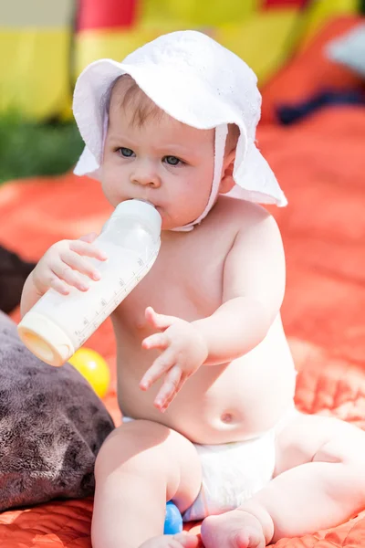 Cute baby girl with bottle of milk — Stock Photo, Image