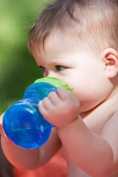 Cute baby drinking from bottle — Stock Photo, Image