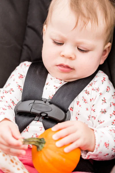 Meisje van de baby met oranje pompoen — Stockfoto