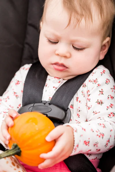 Meisje van de baby met oranje pompoen — Stockfoto