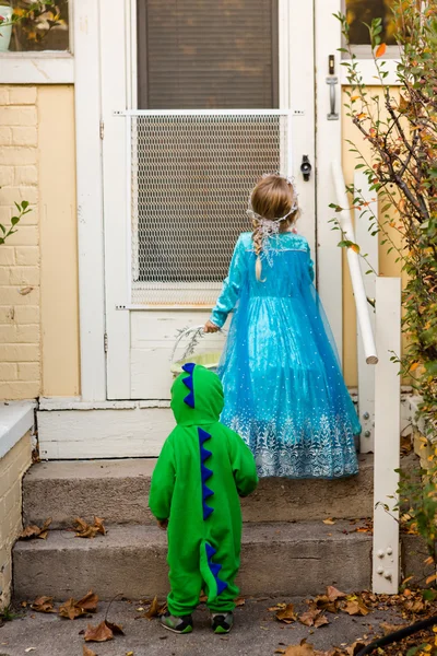 Zwei Kinder in Kostümen tricksen oder behandeln — Stockfoto