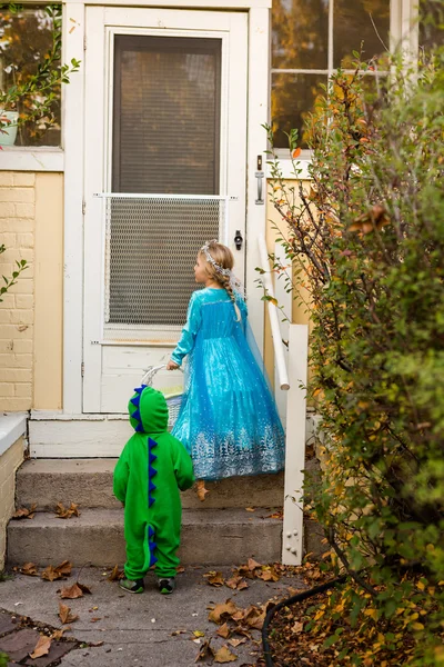 Zwei Kinder in Kostümen tricksen oder behandeln — Stockfoto