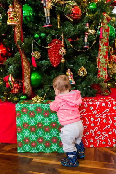 Baby girl looking at Christmas presents — Stock Photo, Image