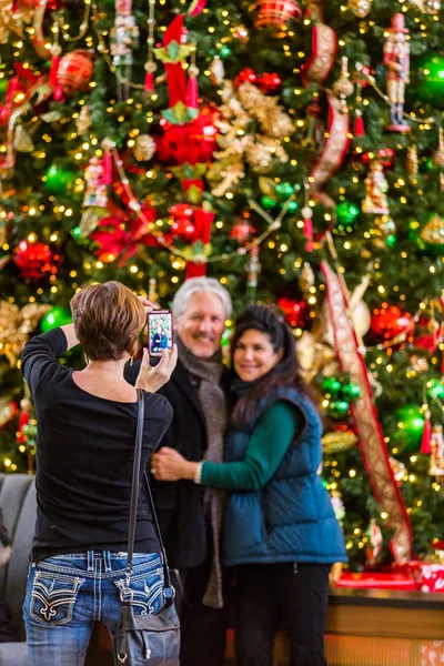 Maduro casal chegando fotografado no Natal árvore — Fotografia de Stock