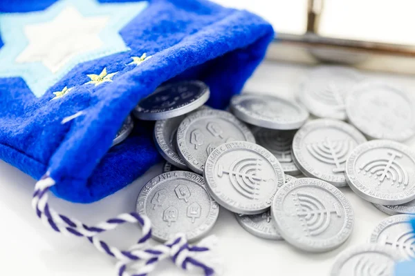 Blue dreidel with silver tokens — Stock Photo, Image
