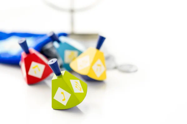 Colorful dreidels with silver tokens, Hanukkah — Stock Photo, Image