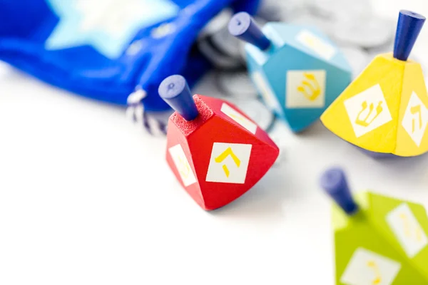 Colorful dreidels with silver tokens — Stock Photo, Image