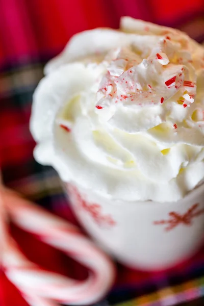 Hot chocolate with whipped cream and crashed peppermint candies — Stock Photo, Image