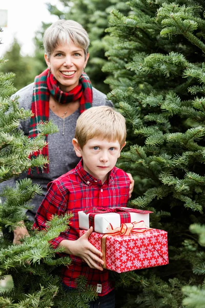 Familie auf Weihnachtsbaumhof mit Geschenken — Stockfoto