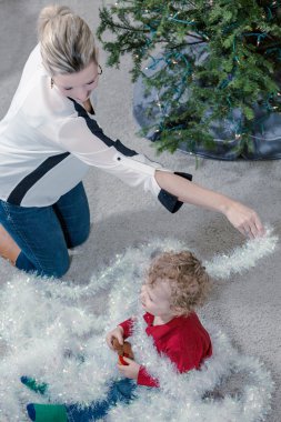 Anne ve oğul Noel ağacı süslüyorlar.