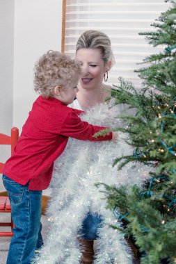 Anne ve oğul Noel ağacı süslüyorlar.