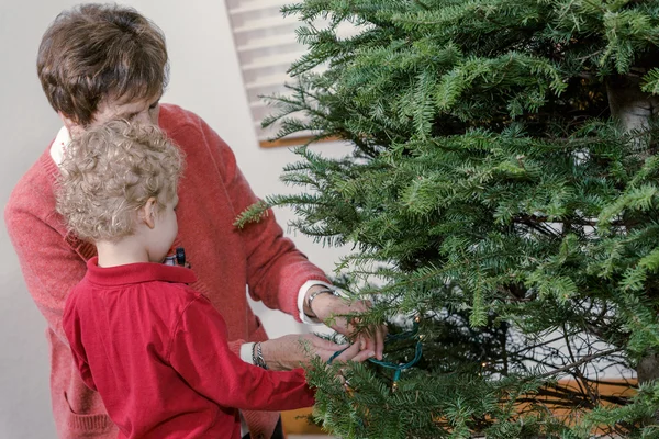 Grand-mère et petit-fils décorant l'arbre de Noël — Photo