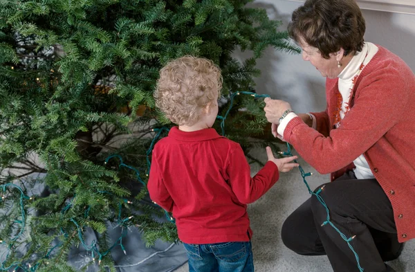 Mormor och barnbarn dekorera julgran — Stockfoto