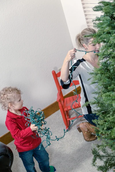 Anne ve oğul Noel ağacı süslüyorlar.