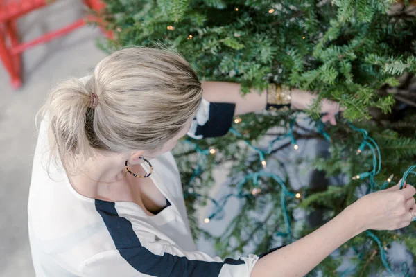 Krásná žena zdobí vánoční stromek — Stock fotografie