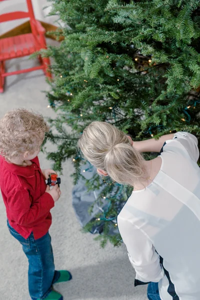 Mor och son dekorerar julgran — Stockfoto