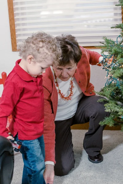 Mormor och barnbarn dekorera julgran — Stockfoto