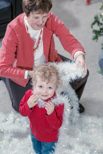 Grand-mère et petit-fils décorant l'arbre de Noël — Photo